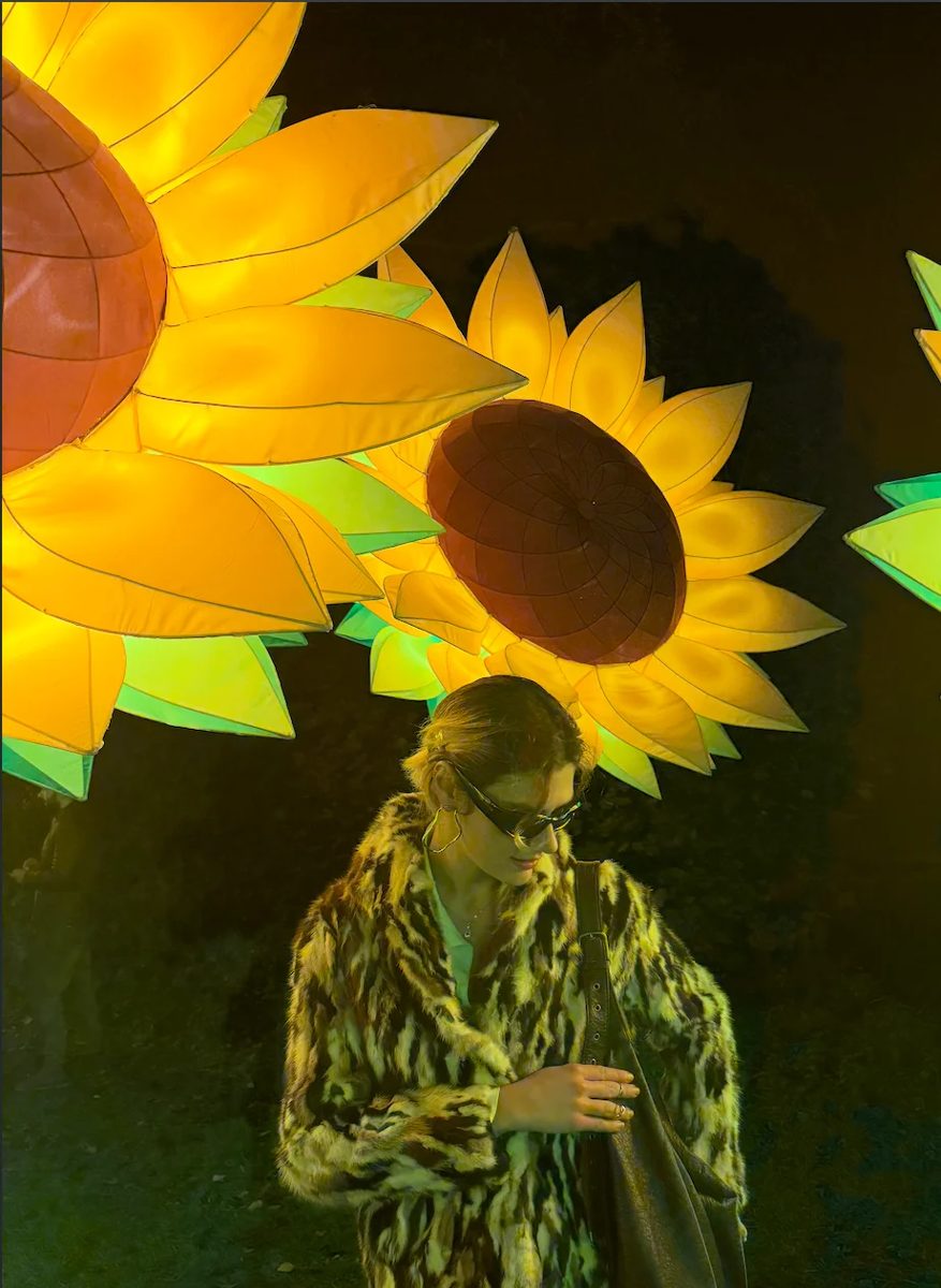 Katya in front of giant glowing sunflowers at GLOW