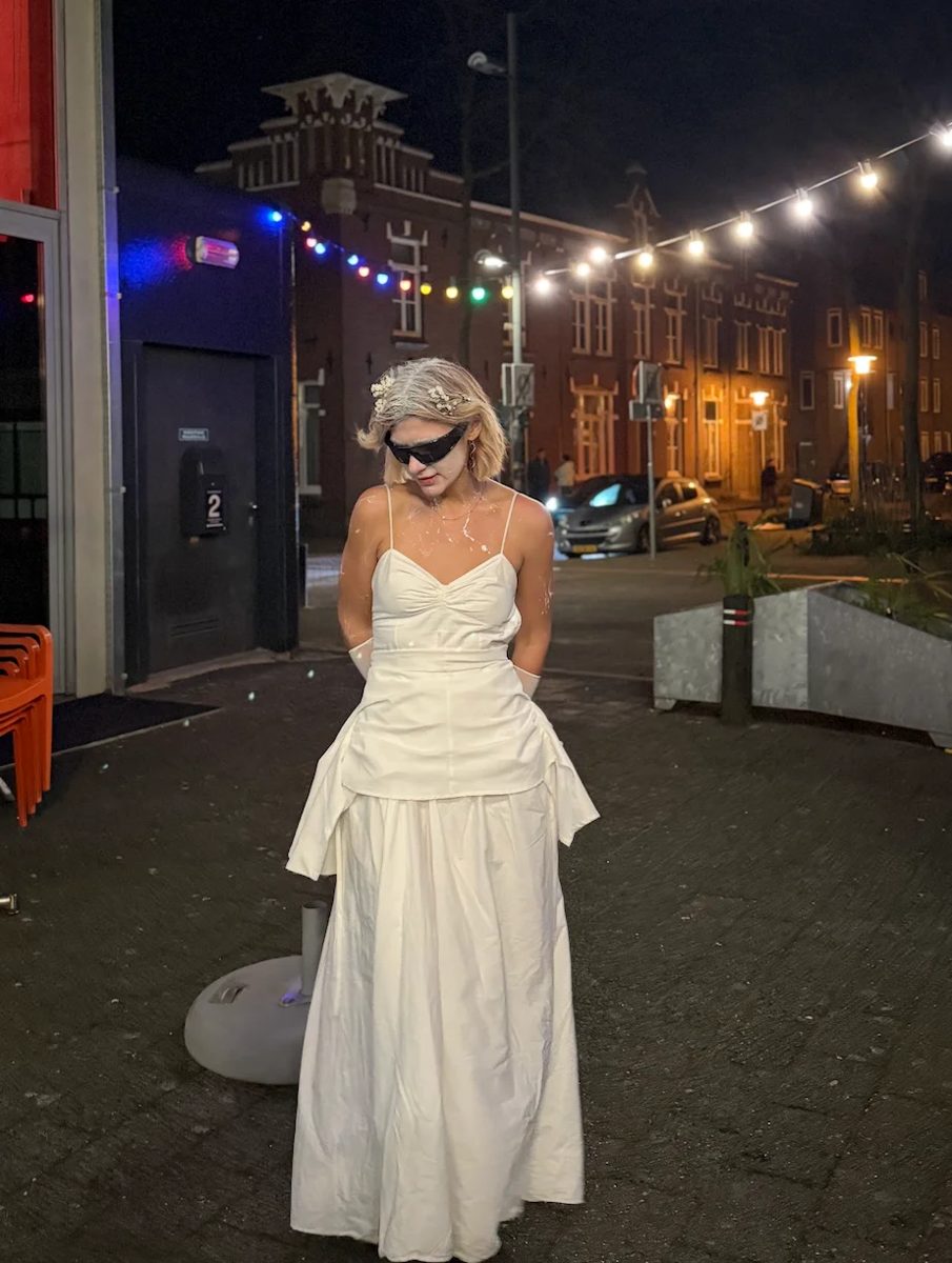 Katya in a white dress on a street at night