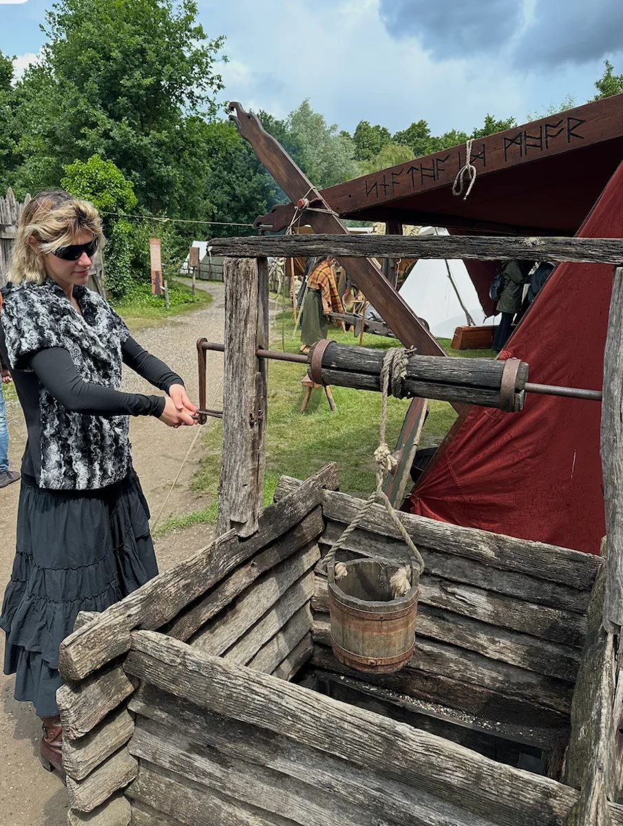 Katya drawing water from a wooden well at Vikingfest