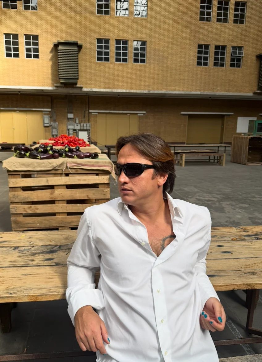 Mahir sitting on a pallet bench at a market