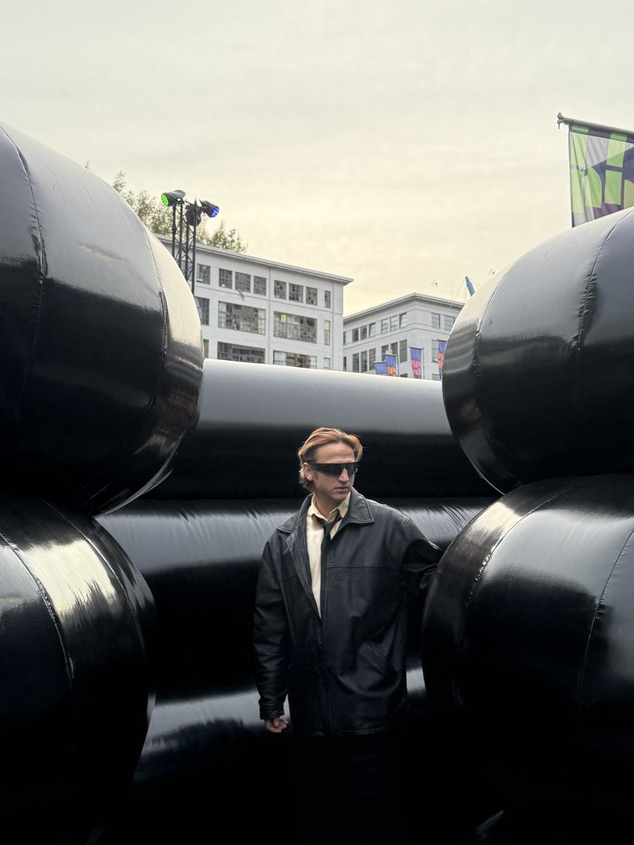 Mahir standing among giant black inflatable shapes in an installation
