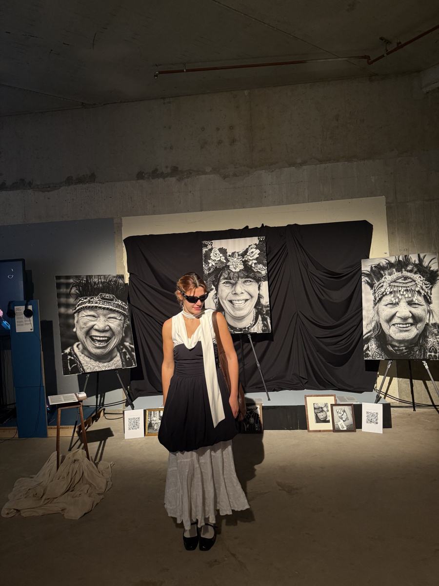Katya in front of large black-and-white portraits at an exhibition